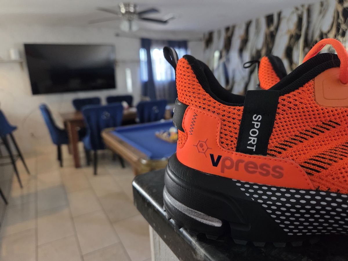 Close-up of an orange Vpress-branded trainer