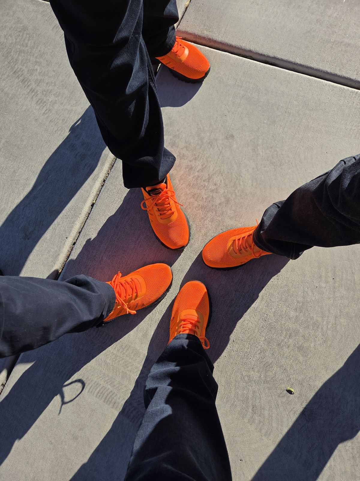 Four pairs of orange Vpress trainers on the pavement in Las Vegas